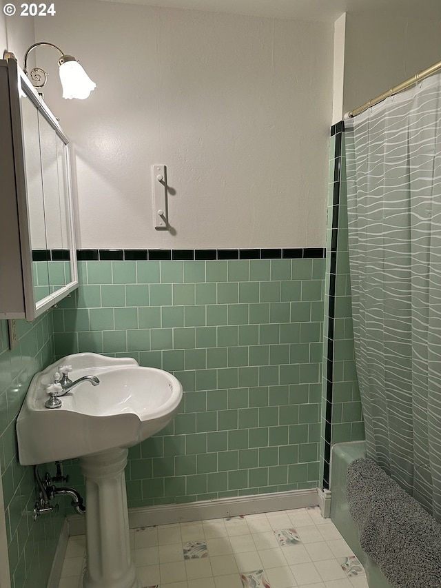 bathroom with shower / bath combo, tile patterned flooring, and tile walls