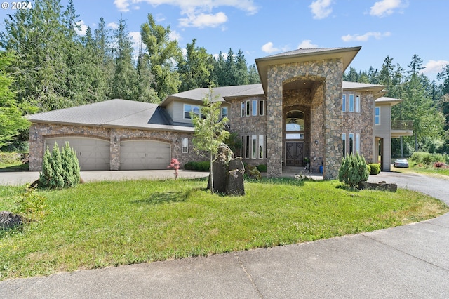 view of front of house featuring a garage and a front lawn