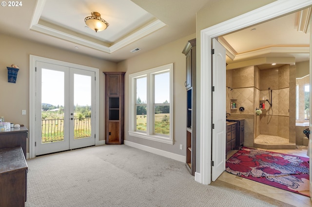 entryway featuring light carpet, french doors, a raised ceiling, and sink