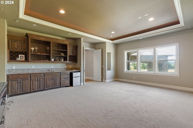 bar with light colored carpet, fridge, and a tray ceiling