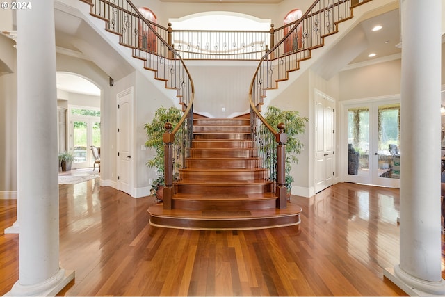 staircase with plenty of natural light, a high ceiling, and french doors