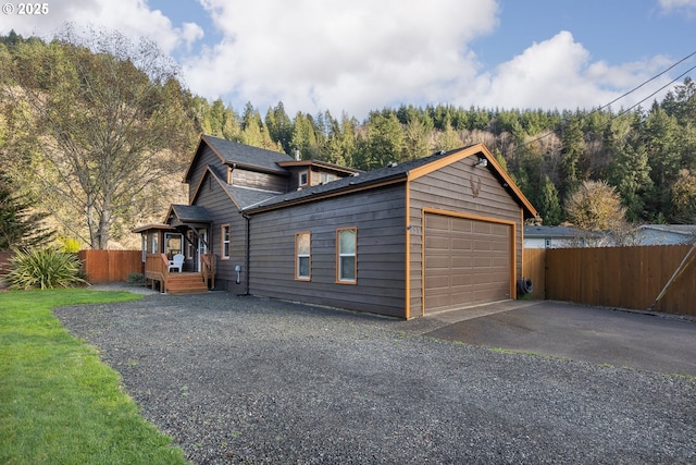 garage with aphalt driveway and fence