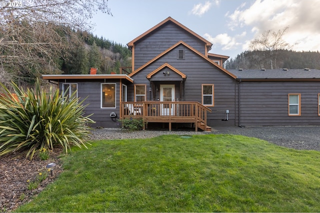 back of property featuring a lawn and a deck