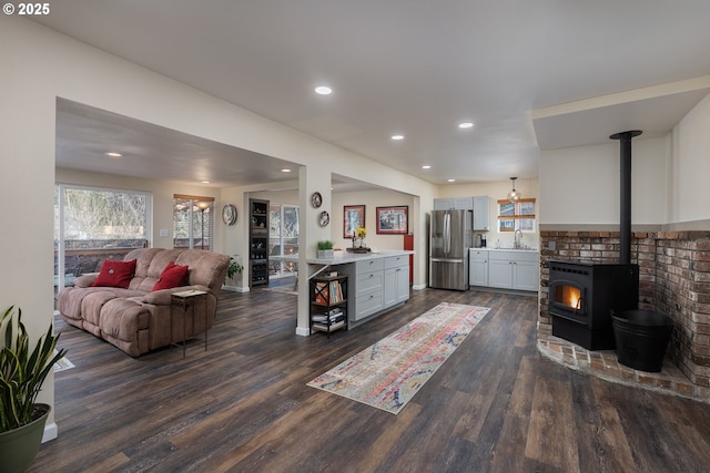 living room with a wood stove, recessed lighting, and dark wood-style flooring