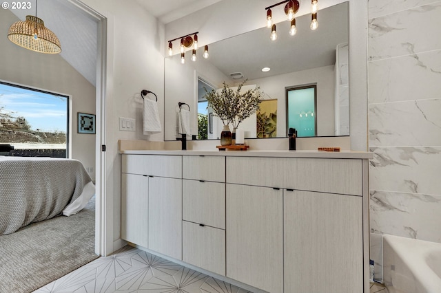 ensuite bathroom with a bath, a sink, connected bathroom, and double vanity