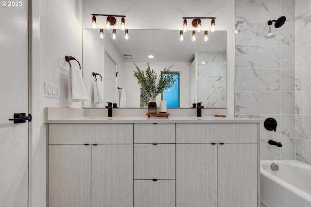 bathroom featuring tiled shower / bath combo and vanity