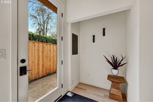 entryway with electric panel, wood finished floors, and baseboards