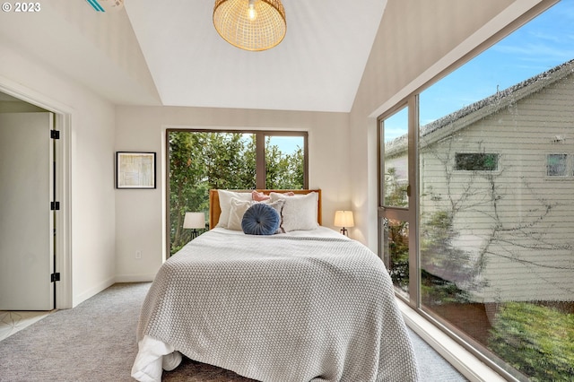 bedroom featuring vaulted ceiling, light carpet, and multiple windows