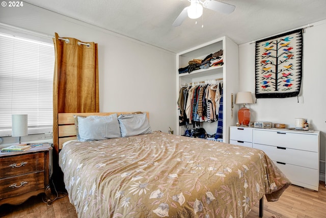 bedroom with a textured ceiling, ceiling fan, light hardwood / wood-style flooring, and a closet