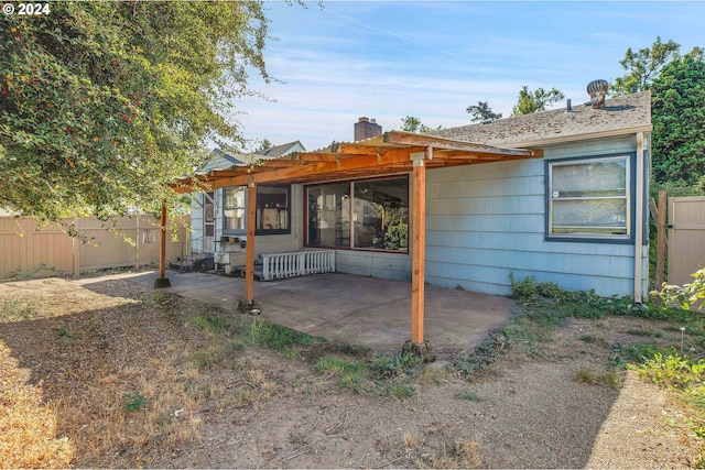 back of property with a pergola and a patio area