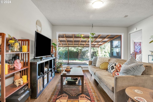 living room with wood-type flooring and a textured ceiling