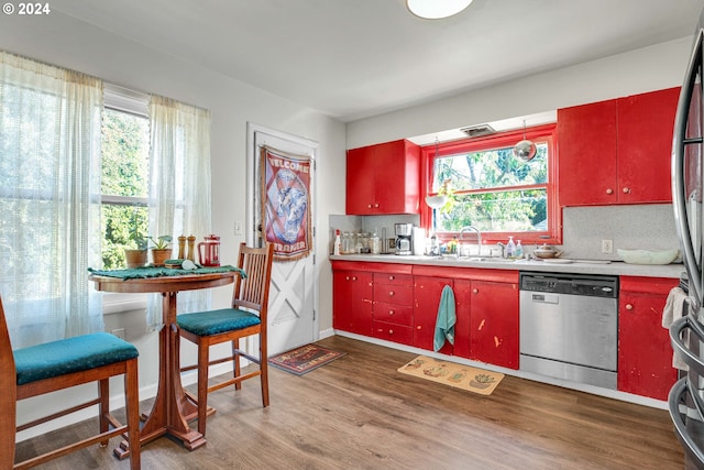 kitchen featuring a wealth of natural light, dishwasher, tasteful backsplash, and dark hardwood / wood-style flooring