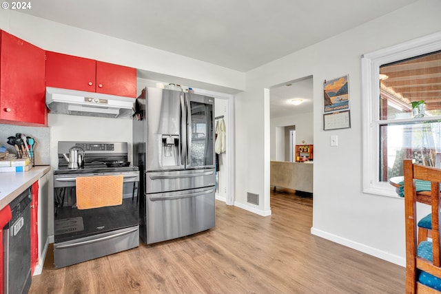 kitchen with appliances with stainless steel finishes and light hardwood / wood-style floors