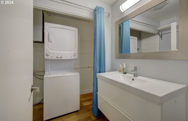 bathroom with wood-type flooring, stacked washer / drying machine, and vanity