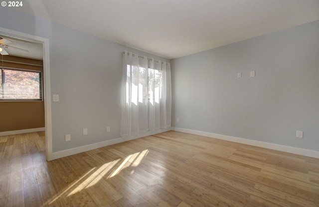 empty room featuring light wood-type flooring and ceiling fan