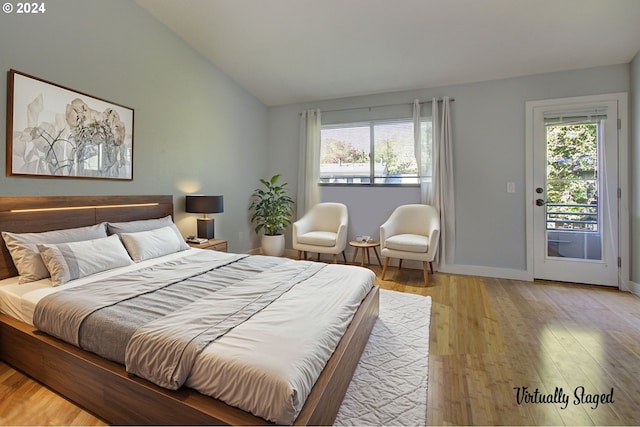 bedroom with multiple windows, access to outside, lofted ceiling, and light hardwood / wood-style flooring