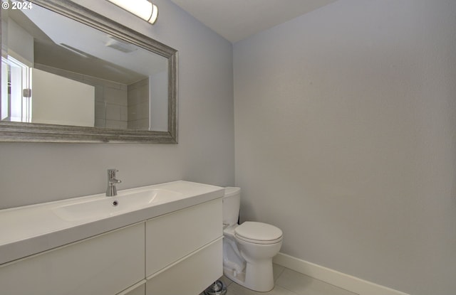 bathroom with tile patterned flooring, vanity, and toilet