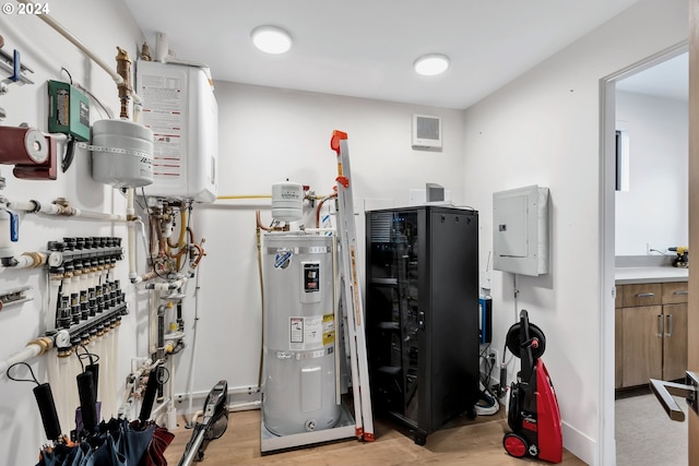 utilities featuring strapped water heater, electric panel, and water heater