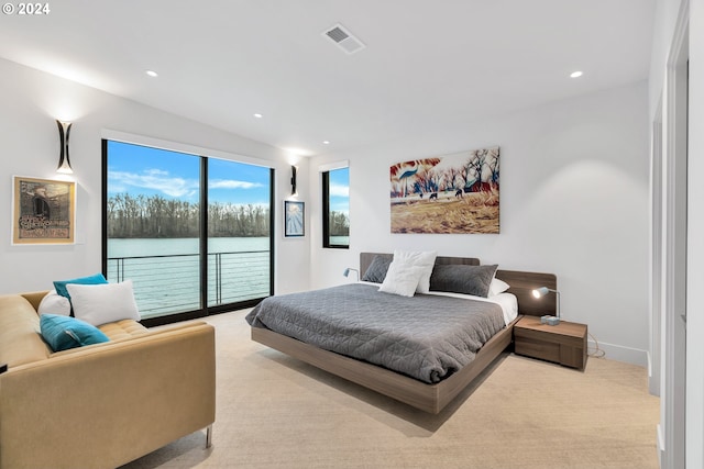 carpeted bedroom with access to exterior and a water view