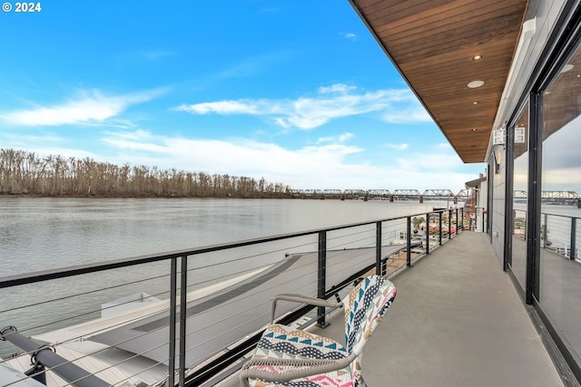 dock area with a water view and a balcony