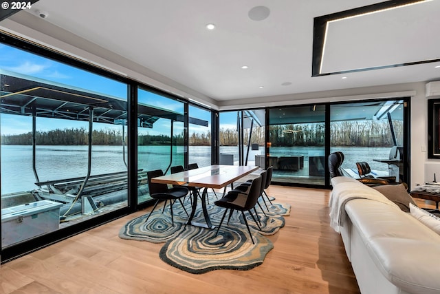 sunroom / solarium with a water view and a wall unit AC