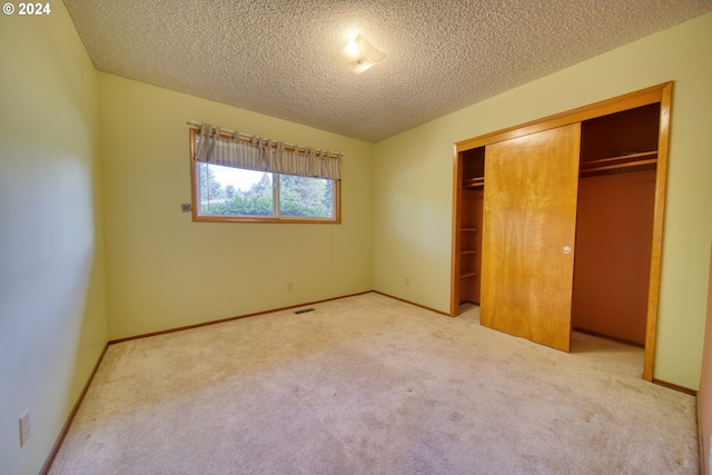 unfurnished bedroom with carpet flooring, a closet, and a textured ceiling