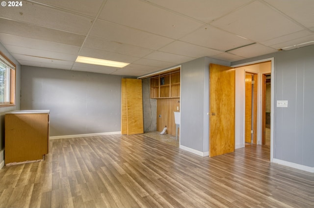 spare room featuring a drop ceiling and wood-type flooring