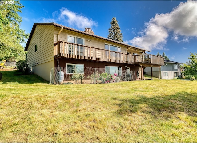 back of house with a deck and a yard