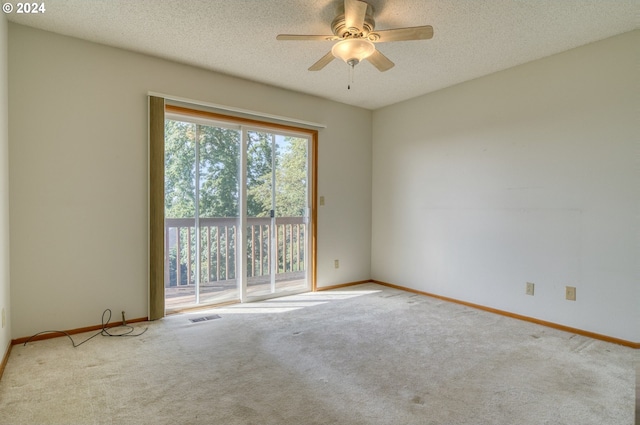 empty room featuring ceiling fan, carpet floors, and a textured ceiling