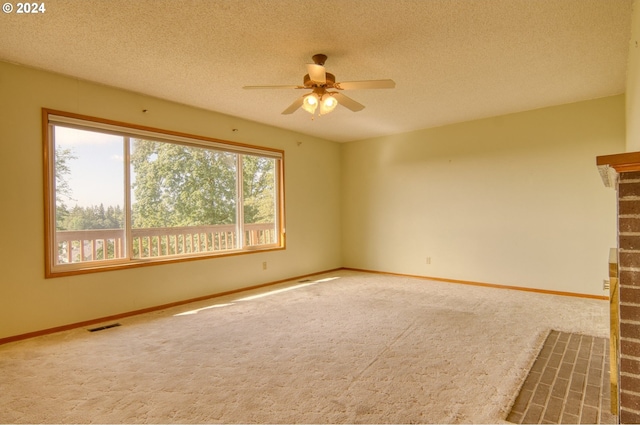 carpeted spare room with ceiling fan and a textured ceiling