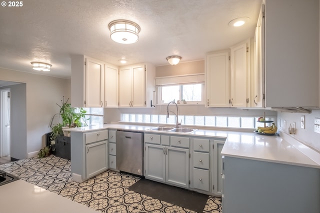 kitchen featuring sink, white cabinetry, a textured ceiling, dishwasher, and kitchen peninsula