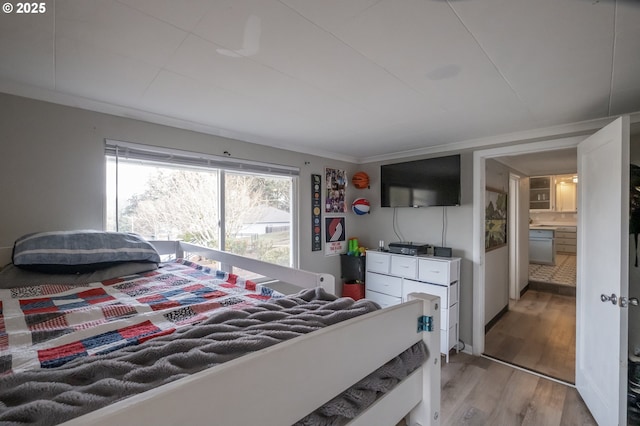 bedroom with crown molding and light hardwood / wood-style flooring