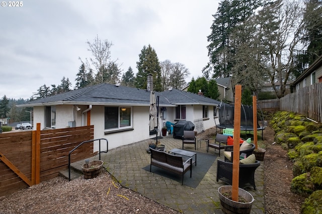 view of patio / terrace with area for grilling, a trampoline, and an outdoor living space with a fire pit