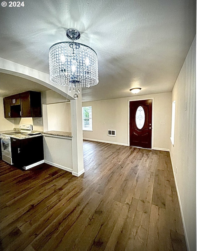 foyer entrance featuring a chandelier, a textured ceiling, and dark hardwood / wood-style flooring