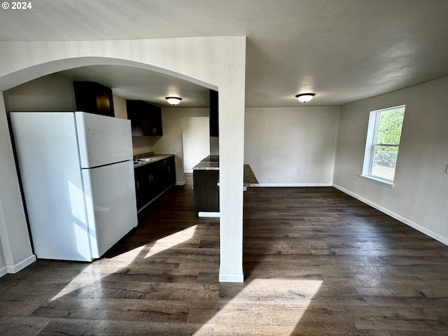 kitchen featuring white refrigerator, dark hardwood / wood-style floors, and a textured ceiling