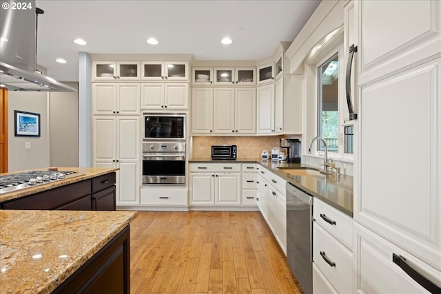 kitchen with sink, stainless steel appliances, extractor fan, light stone countertops, and white cabinets