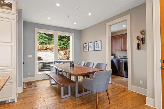 dining space with independent washer and dryer and light hardwood / wood-style flooring