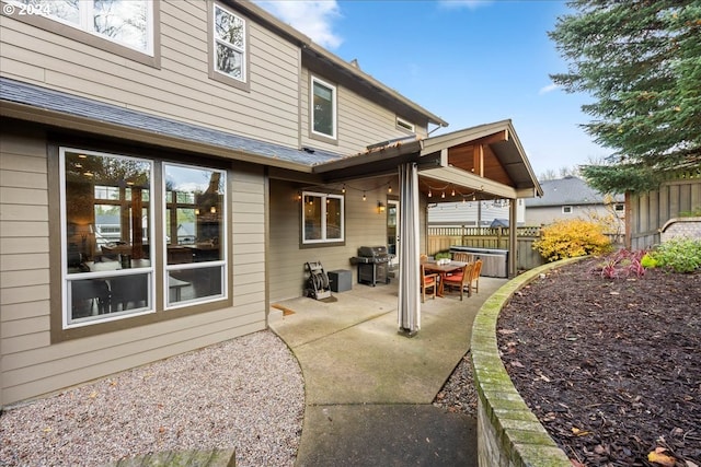 rear view of property featuring a jacuzzi and a patio area