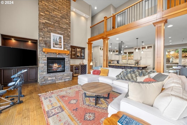 living room with ornate columns, a fireplace, and light hardwood / wood-style floors