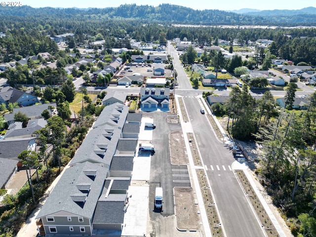 1587 37th St, Florence, OR 97439 - aerial overview of property's location with nearby suburban area and a mountainous background