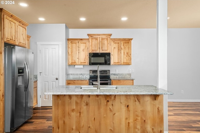 kitchen with light stone countertops, stainless steel appliances, and dark hardwood / wood-style floors