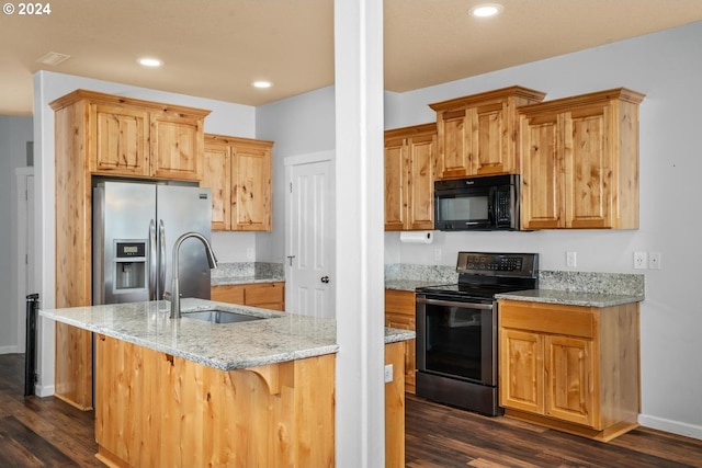 kitchen with light stone countertops, a breakfast bar, black appliances, and dark hardwood / wood-style floors