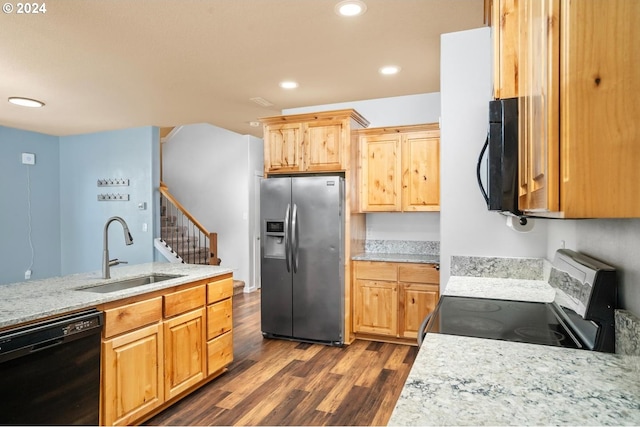 kitchen with light brown cabinets, dark wood-type flooring, black appliances, sink, and light stone counters