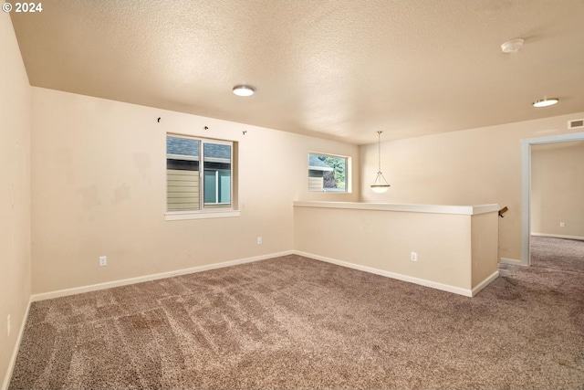 unfurnished room featuring carpet flooring and a textured ceiling