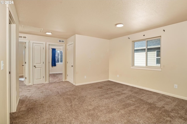 carpeted spare room with a textured ceiling