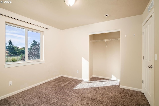 unfurnished bedroom with carpet flooring and a closet