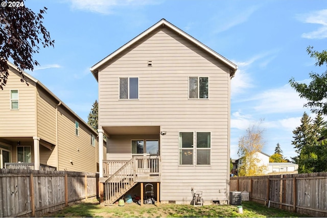 rear view of property with a lawn and central air condition unit