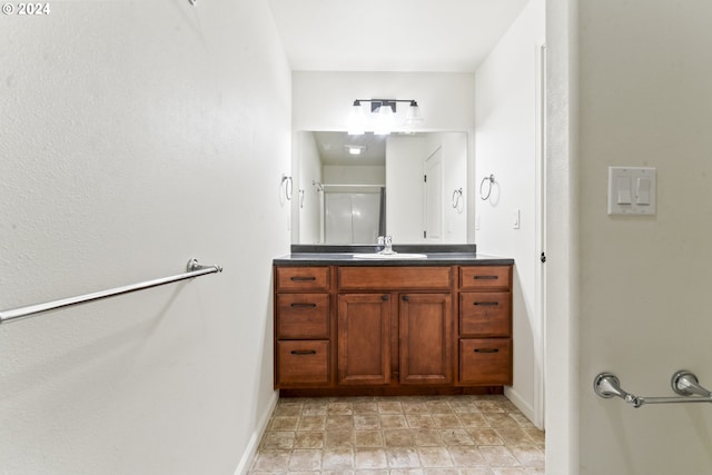 bathroom with walk in shower, vanity, and baseboards