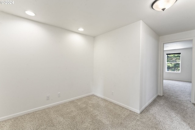 unfurnished room with baseboards, recessed lighting, and light colored carpet