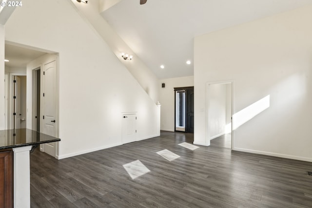 unfurnished living room with dark wood-style floors, baseboards, high vaulted ceiling, and recessed lighting